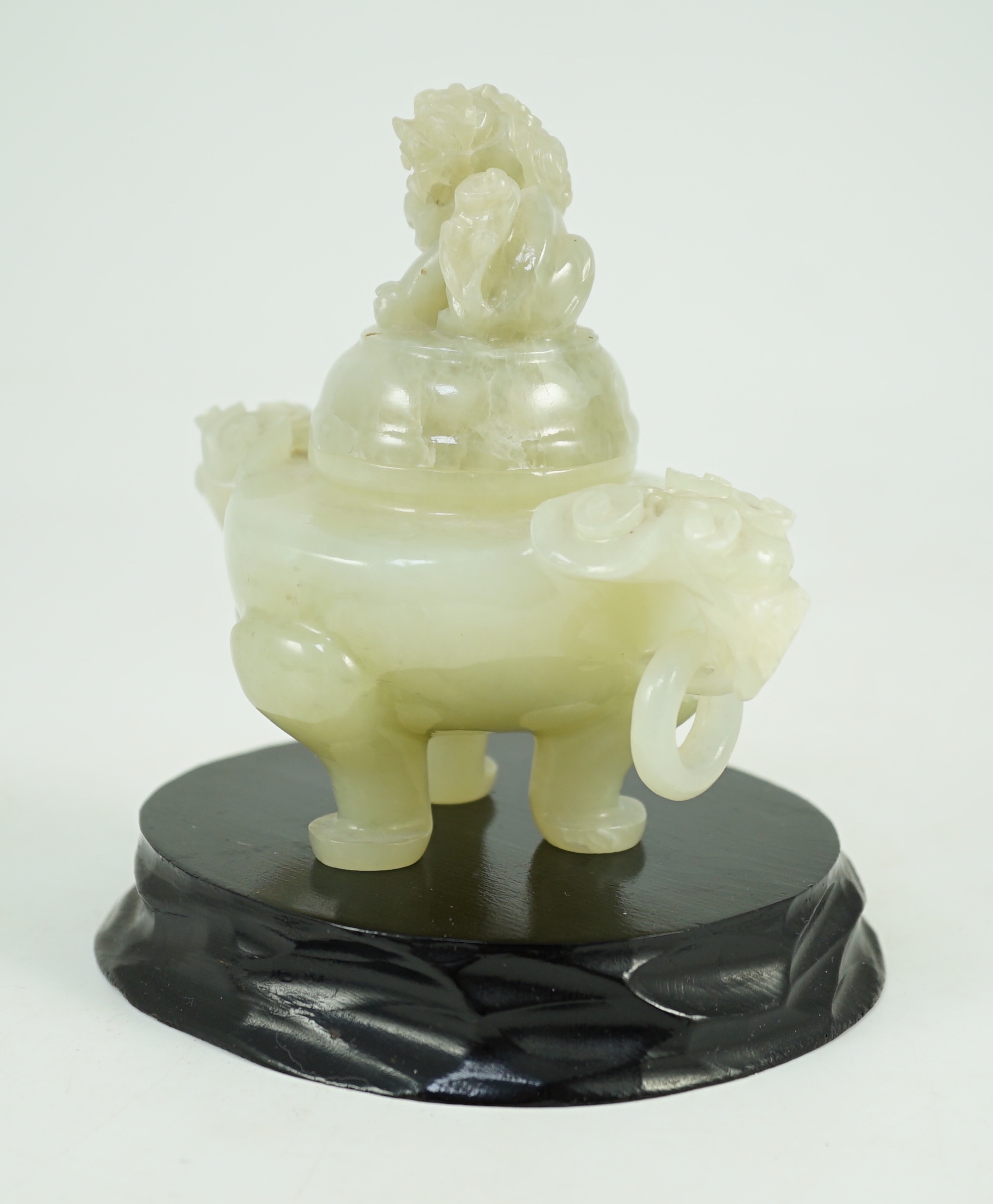 A Chinese pale celadon jade tripod censer cover, 20th century, 12cm wide, wood stand